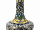 a blue and gold vase sitting on a white surface