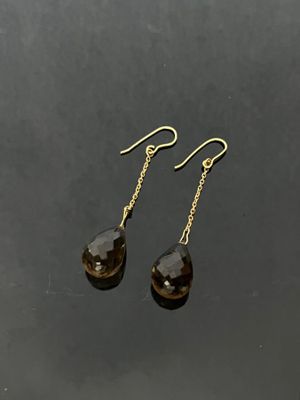 a pair of smoky quartz drop earrings on a black surface
