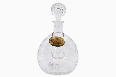 crystal decante bottle with a gold coin on the top
