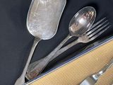 a box with silverware on a table with a spoon and fork