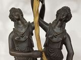 a statue of two people holding a snake in their hands