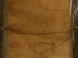 an old picture of a wooden frame with a rope hanging from it