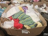 de nombreux cartons remplis de vêtements qui traînent par terre