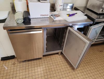 une petite cuisine équipée d'un réfrigérateur et d'un lave-vaisselle