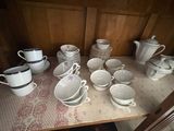 many cups and saucers sitting on a table