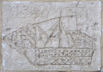an image of a stone plaque with a ship carved into it