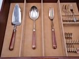 a wooden drawer with silverware and utensils in it