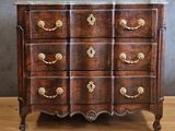 an antique chest of drawers with marble top and brass handles