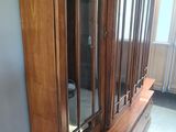 a large wooden cabinet with a mirror on top of it