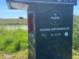 a sign for a pizza restaurant on the side of the road