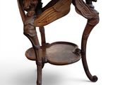 a wooden table with a glass top and a bird on it
