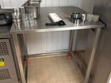 a stainless steel table with pots and pans on it