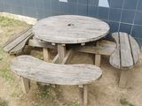 a wooden table and two benches in front of a blue wall