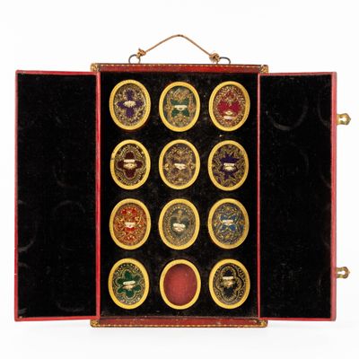 un étui rouge contenant douze pièces de couleurs différentes