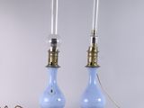 une paire de lampes en verre bleu avec des ferrures en laiton et une corde
