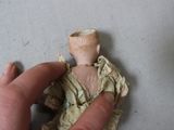 a hand that is holding a doll on a table
