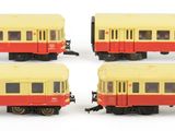 four yellow and red train cars sitting next to each other on a white surface