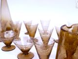 bottles and glasses are lined up on a table with a pitcher