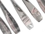 six silverware spoons are lined up in a row on a white surface