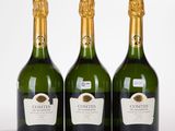 trois bouteilles de vin posées les unes à côté des autres sur une surface blanche
