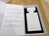 perfume bottle in a white box on a wooden table
