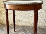 a small table with a glass top on a brick floor