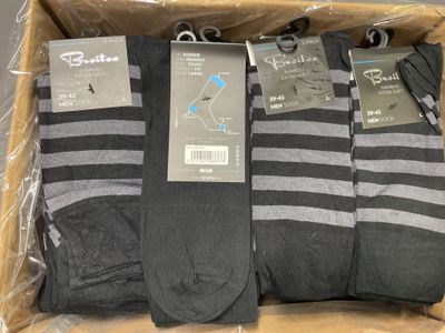 trois paires de chaussettes noires et grises pour homme dans une boîte