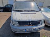 a dirty van parked in a parking lot next to other cars