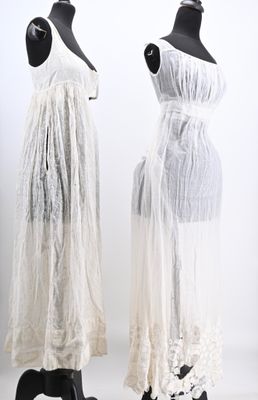 two mannequins dressed in white dresses on display in a white room
