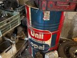 a large metal barrel sitting on the floor next to a pile of other items