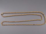 a close up of a gold chain on a gray surface
