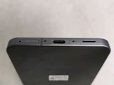 the back of a black cell phone sitting on top of a table