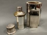 a silver vase and a silver shaker on a table