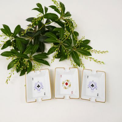four small white and gold plates with flowers and leaves on them