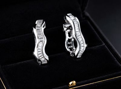 pair of diamond earrings in a black box on a black background