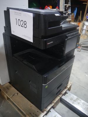 une pile d'imprimantes posée sur une palette dans un entrepôt