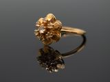 a close up of a gold ring with a flower on it