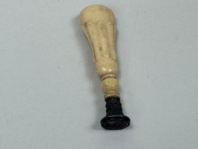 une batte de baseball avec un manche en bois posée sur une surface blanche