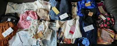 many different types of clothing on the couch