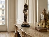 une statue représentant une femme debout sur une table dans une pièce