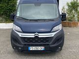 Une camionnette bleue est garée devant un immeuble.