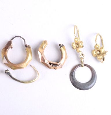 three pairs of gold and silver ear rings and a horn shaped earring