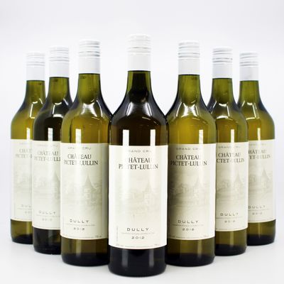 six bottles of wine are lined up in a row on a white surface