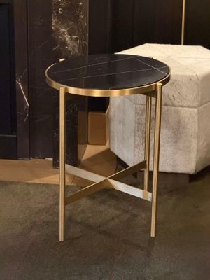 a black and gold side table with a white ottoman