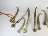 several different types of knives are lined up on a white surface