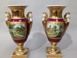 pair of antique vases with hand painted scenes on them sitting on a table