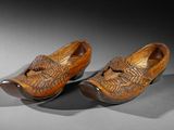 pair of wooden clogs with carved design on the toes