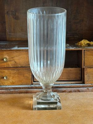 a glass vase sitting on a table in front of a dresser