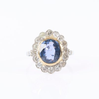 an image of a ring with a blue sapphire and diamonds