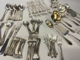 un grand nombre de cuillères et de fourchettes en argent disposées sur une table